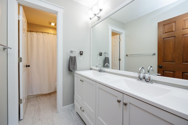 full bathroom featuring marble finish floors, toilet, double vanity, baseboards, and curtained shower