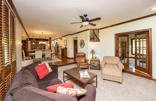 living room featuring crown molding, a ceiling fan, carpet, a textured ceiling, and baseboards
