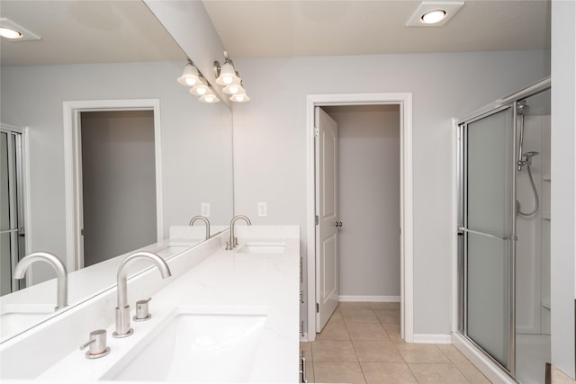 full bath with a shower stall, tile patterned floors, baseboards, and double vanity