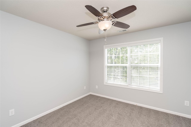 spare room with carpet floors, baseboards, and a ceiling fan