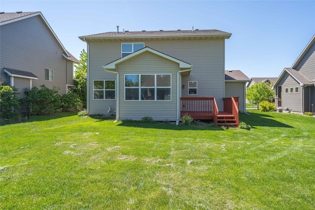 rear view of property with a wooden deck and a yard