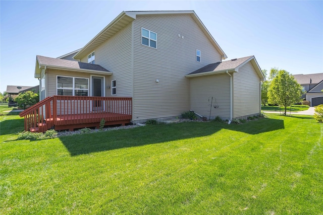 rear view of property featuring a deck and a yard