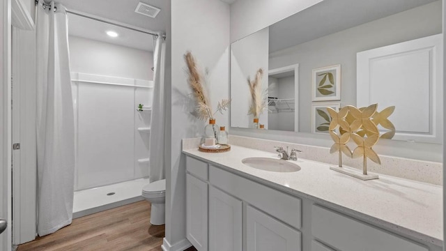1415 Northview Dr, Waukee, IA 50263 - bathroom featuring toilet, a stall shower, vanity, and wood finished floors