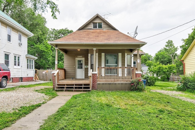 1360 E 9th St, Des Moines, IA 50316 - bungalow featuring covered porch, a front yard, and a shingled roof