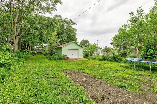 1360 E 9th St, Des Moines, IA 50316 - view of green lawn with a trampoline, a garage, and an outbuilding