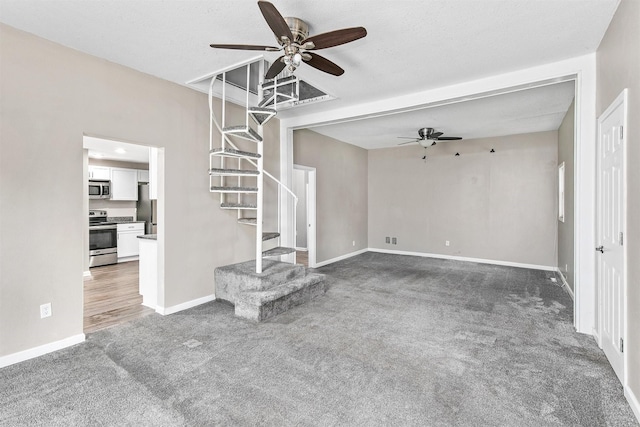1360 E 9th St, Des Moines, IA 50316 - unfurnished living room featuring ceiling fan, stairway, and carpet floors