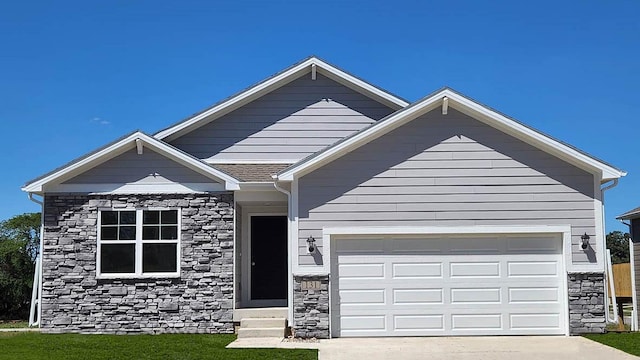 view of front of home with stone siding, concrete driveway, an attached garage, and entry steps