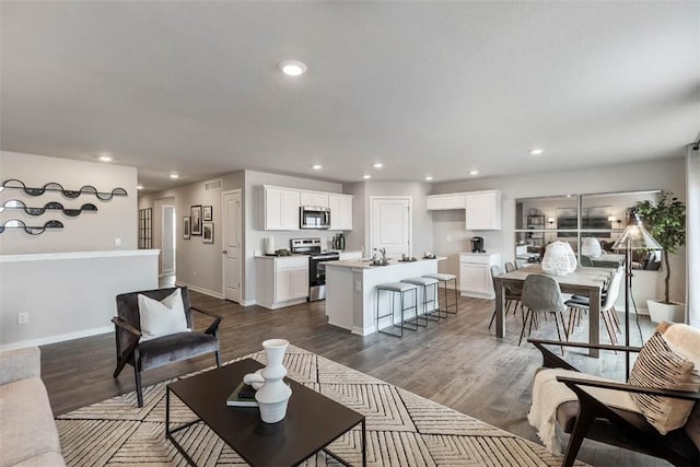 living area with recessed lighting, dark wood-style floors, and baseboards