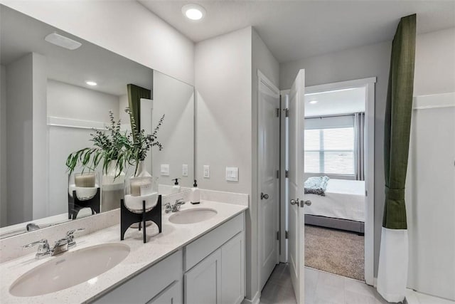 ensuite bathroom featuring double vanity and recessed lighting