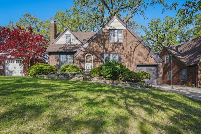 1534 41st St, Des Moines, IA 50311 - tudor home featuring brick siding, a chimney, a front lawn, and driveway