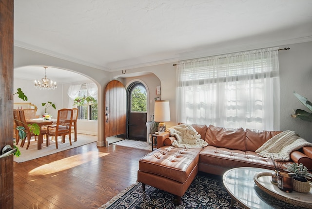1534 41st St, Des Moines, IA 50311 - living room featuring arched walkways, wood finished floors, ornamental molding, a chandelier, and baseboards