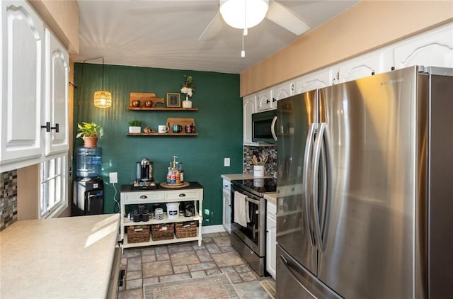1534 41st St, Des Moines, IA 50311 - kitchen with stainless steel appliances, stone finish floors, white cabinets, and ceiling fan