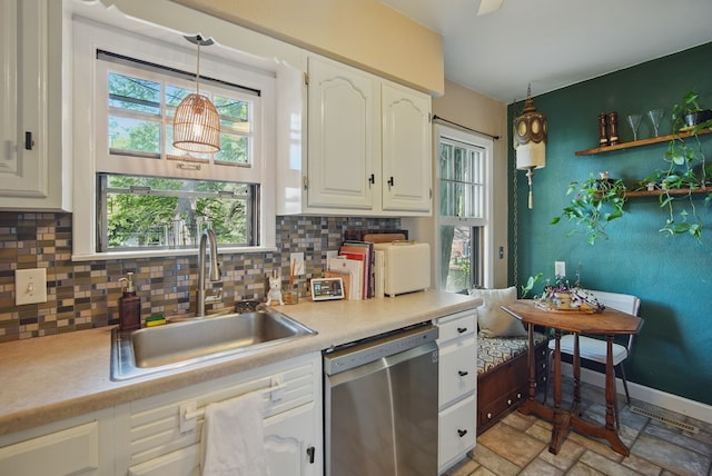 1534 41st St, Des Moines, IA 50311 - kitchen with stainless steel dishwasher, a sink, decorative backsplash, white cabinets, and light countertops