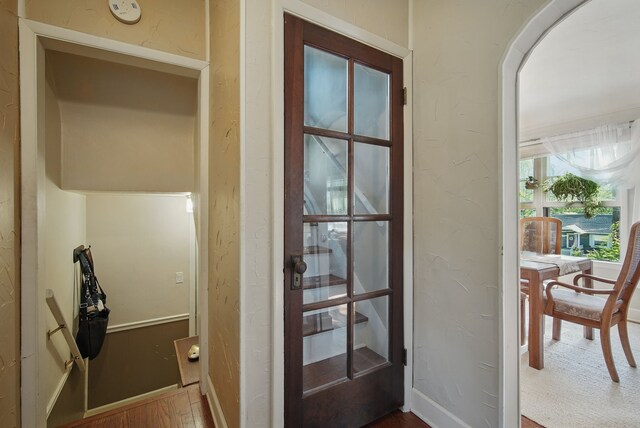 1534 41st St, Des Moines, IA 50311 - doorway to outside featuring wood finished floors, a textured wall, and baseboards