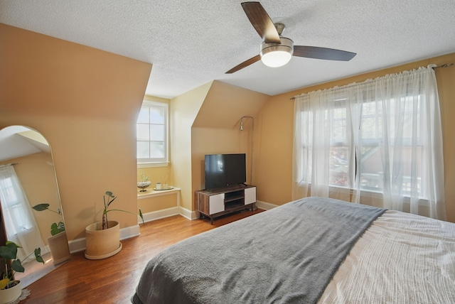 1534 41st St, Des Moines, IA 50311 - bedroom with a textured ceiling, wood finished floors, baseboards, arched walkways, and ceiling fan