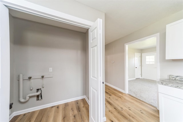 408 E Benton St, Winterset, IA 50273 - washroom with light wood-style flooring and washer hookup