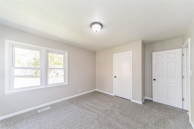 408 E Benton St, Winterset, IA 50273 - unfurnished bedroom featuring carpet floors and baseboards