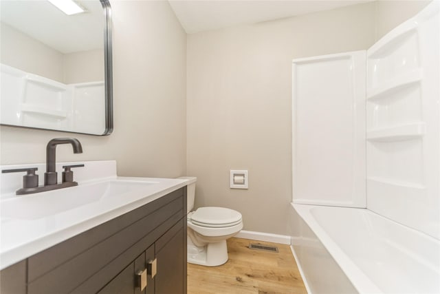 408 E Benton St, Winterset, IA 50273 - full bath featuring wood finished floors, vanity, and shower / tub combination