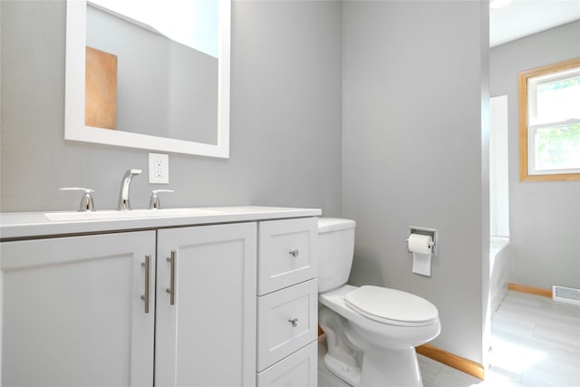 bathroom with toilet, vanity, and baseboards