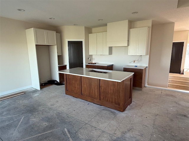kitchen featuring a center island, white cabinets, baseboards, and recessed lighting