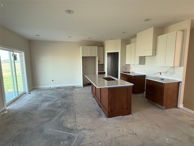 kitchen featuring a center island, white cabinetry, baseboards, and recessed lighting