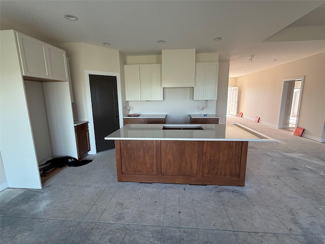 kitchen featuring a center island, white cabinets, custom range hood, baseboards, and recessed lighting