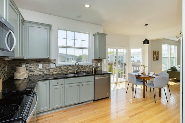 213 Bridgewood Dr, West Des Moines, IA 50266 - kitchen featuring stainless steel appliances, gray cabinetry, light wood-style floors, tasteful backsplash, and healthy amount of natural light