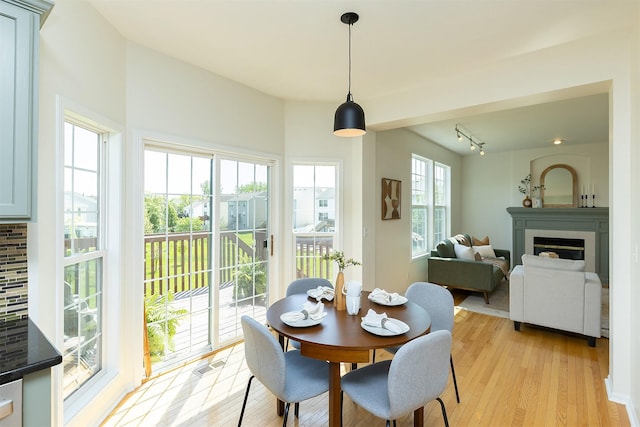 213 Bridgewood Dr, West Des Moines, IA 50266 - dining area with a glass covered fireplace and light wood-style floors