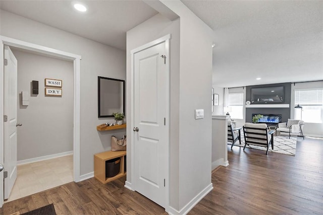 hallway featuring wood finished floors, baseboards, and recessed lighting