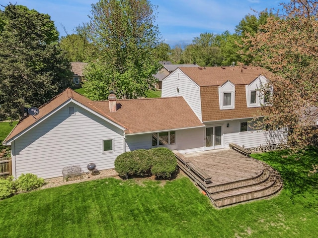 rear view of property with roof with shingles and a yard