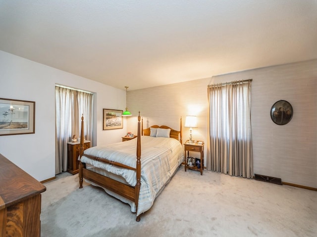 bedroom featuring light colored carpet and baseboards