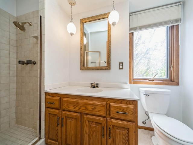 bathroom with a stall shower, healthy amount of natural light, toilet, and vanity