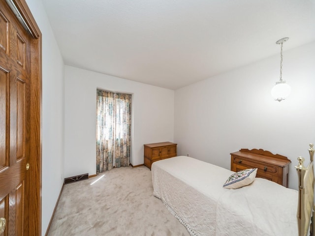 bedroom with light carpet and baseboards