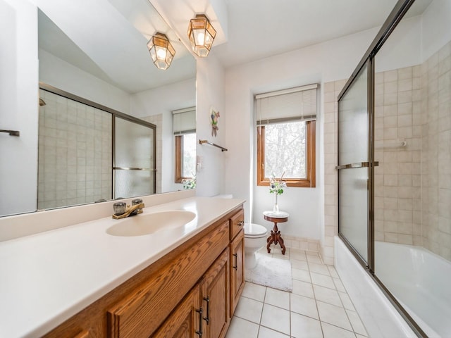 full bath featuring tile patterned floors, vanity, shower / bath combination with glass door, and toilet