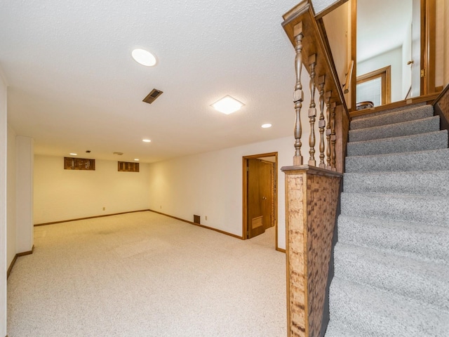 finished basement with stairs, recessed lighting, light carpet, and baseboards