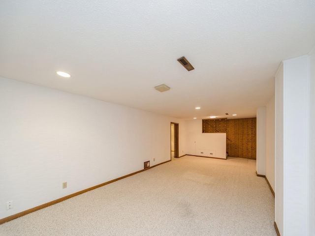 empty room featuring light colored carpet, baseboards, and recessed lighting