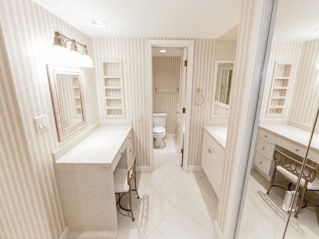 bathroom with wallpapered walls, toilet, vanity, and tile patterned flooring