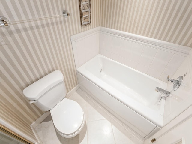 full bathroom featuring wallpapered walls, toilet, a tub, and baseboards
