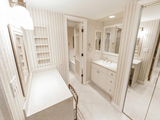 bathroom with wallpapered walls, vanity, tile patterned floors, and baseboards