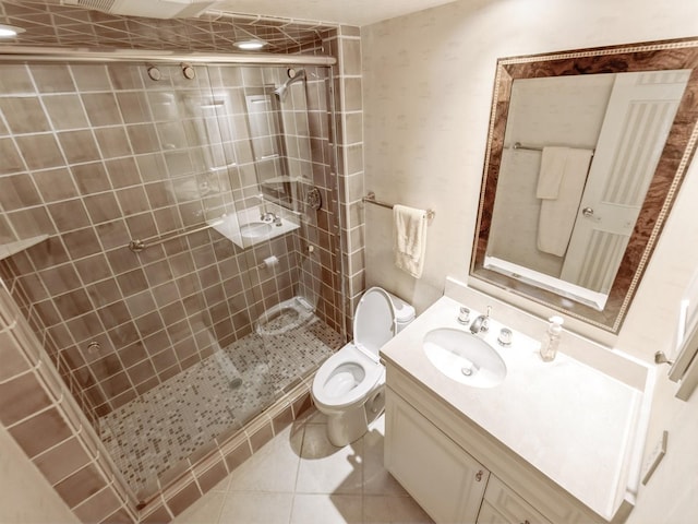 bathroom featuring toilet, tile patterned floors, a stall shower, and vanity