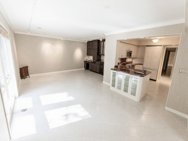 unfurnished living room featuring crown molding, a sink, baseboards, and light tile patterned floors