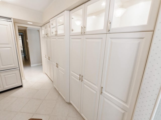 hall with light tile patterned floors and wallpapered walls