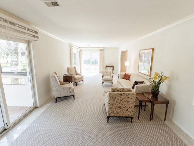 living area with ornamental molding, baseboards, and light carpet