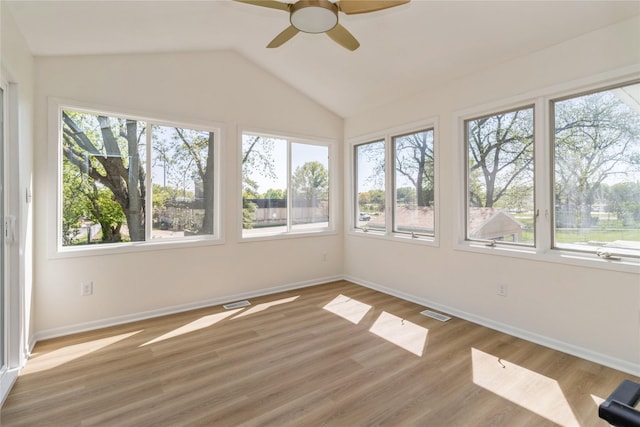 unfurnished sunroom featuring plenty of natural light, baseboards, and vaulted ceiling