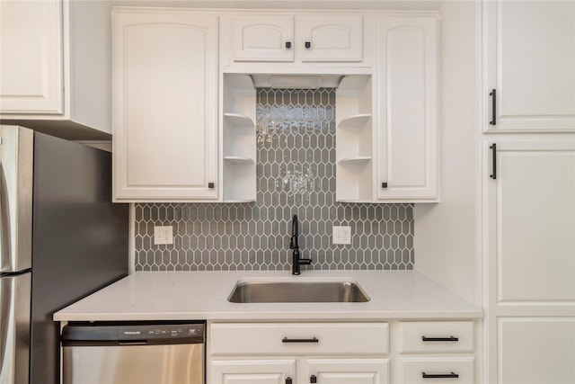 kitchen with appliances with stainless steel finishes, open shelves, a sink, light countertops, and tasteful backsplash