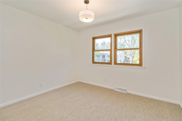 unfurnished room featuring light colored carpet and baseboards