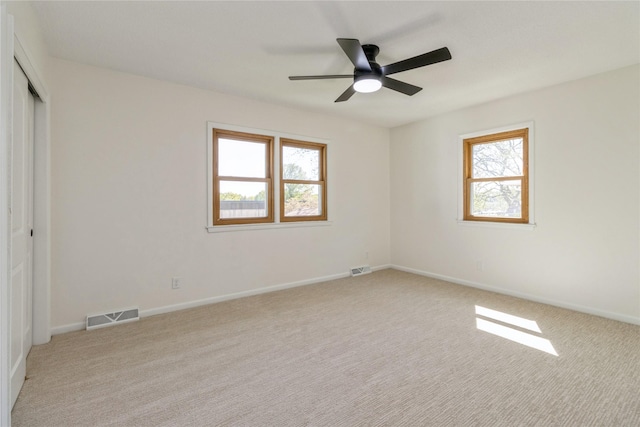 unfurnished bedroom with multiple windows, light colored carpet, a closet, and baseboards