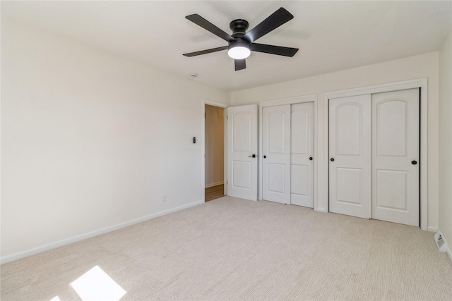 unfurnished bedroom with multiple closets, carpet flooring, and baseboards
