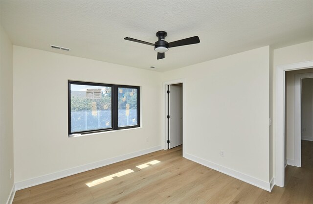 4727 Hillsdale Dr, Urbandale, IA 50322 - unfurnished bedroom with light wood finished floors, baseboards, ceiling fan, and a textured ceiling