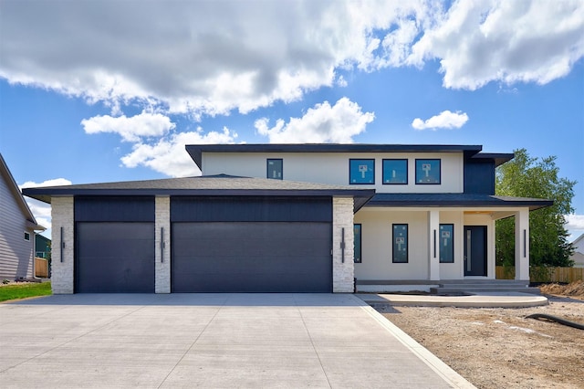 4727 Hillsdale Dr, Urbandale, IA 50322 - prairie-style home featuring an attached garage, concrete driveway, covered porch, brick siding, and stucco siding